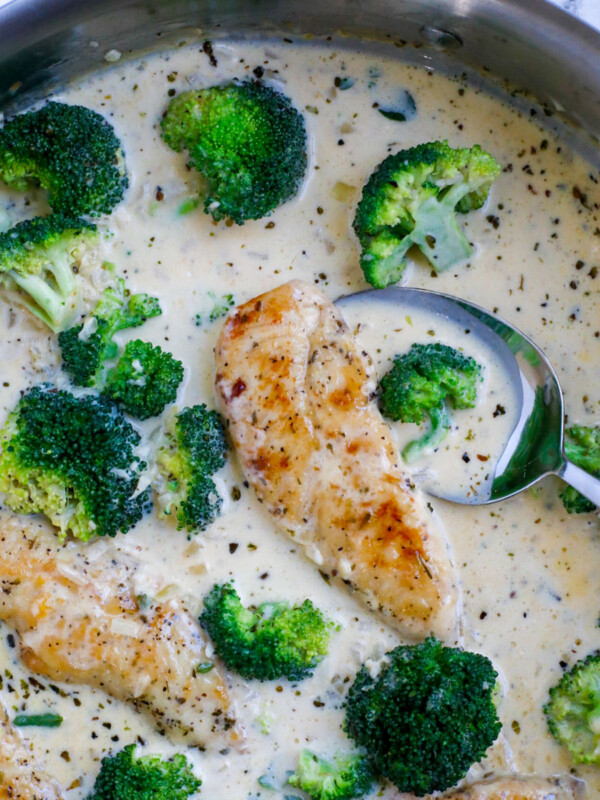 A spoon dipping into a pot of creamy chicken broccoli.