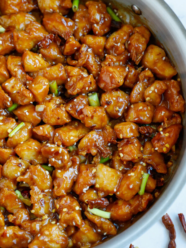 Close up of a skillet with bite sized pieces of general tso chicken.