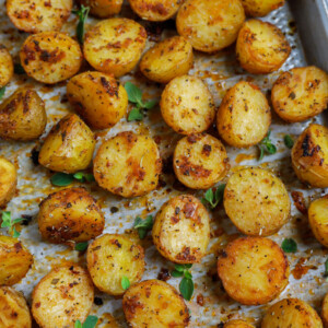 Top down shot of oven roasted baby potatoes on a sheet pan.
