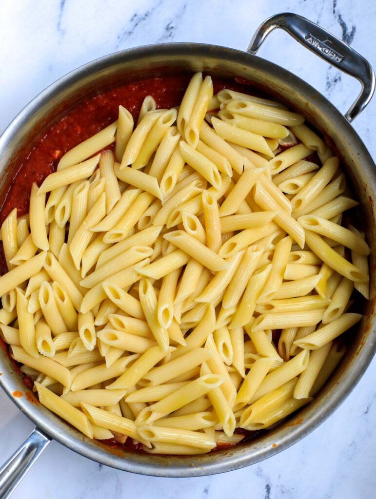 Pasta in a pot with tomato sauce.