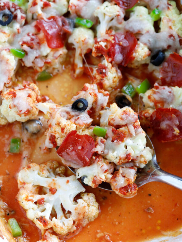 spoon taking out a scoop of Pizza Casserole from a baking dish