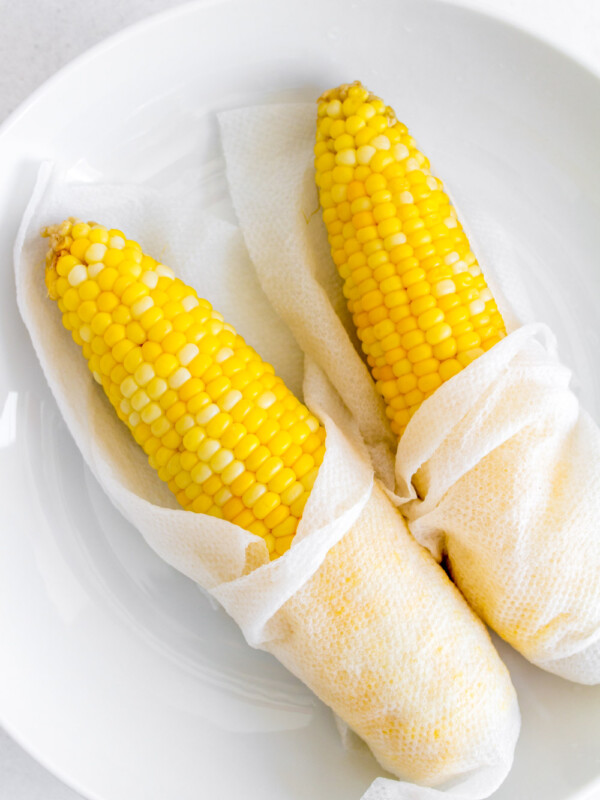 cooked corn on a plate wrapped with paper towel.