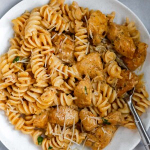 A bowl of creamy cajun chicken pasta with a fork inside.