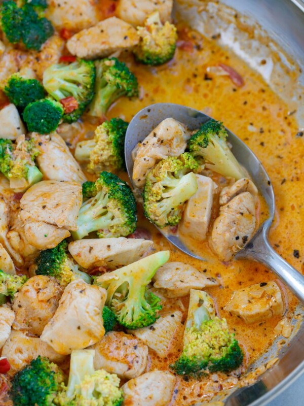 Close up of a spoonful of sun-dried tomato chicken and broccoli.