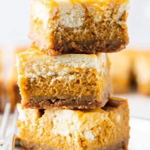 3 stacks of the pumpkin cheesecake bars in a close up shot