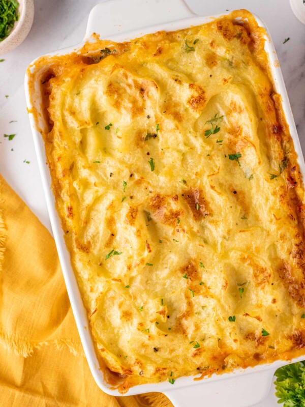 Chicken Shepherds pie in a white baking dish, garnished with parsley