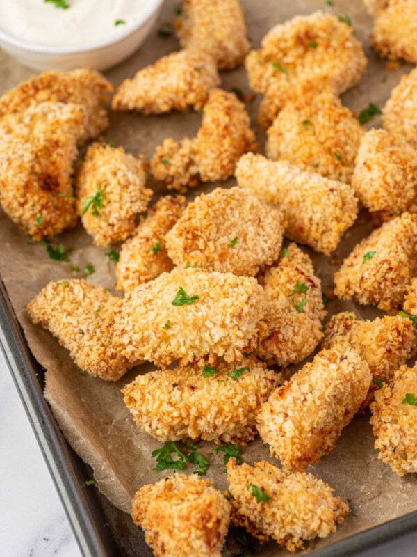 Crispy popcorn chicken on a baking sheet.