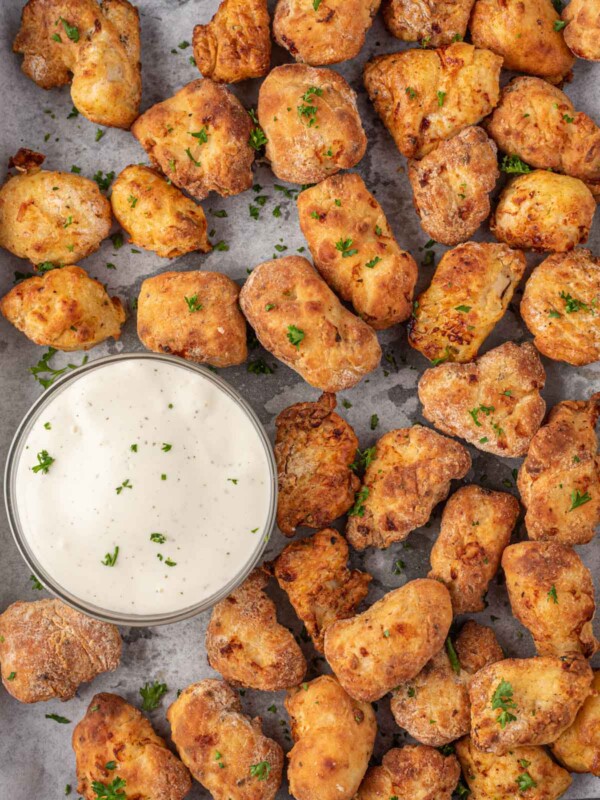 Popcorn chicken air fryer on a tray with a bowl of dip.