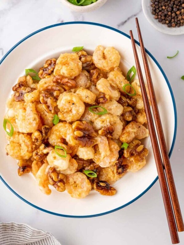 Walnut shrimp in a bowl with a pair of chopsticks.