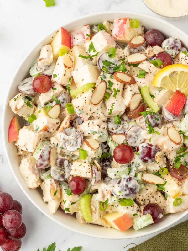 Chicken salad in a bowl topped with slices of almonds.