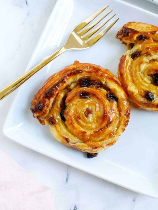 baked pain aux raisins served on a plate with fork.