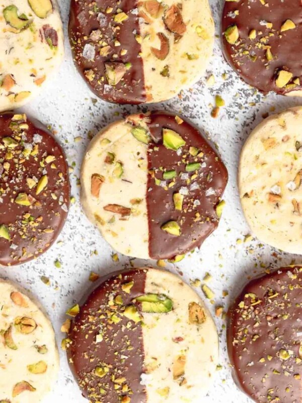 Chocolate dipped pistachio cookies on a tray.