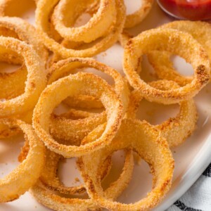 Closeup of panko crusted onion rings on a plate.