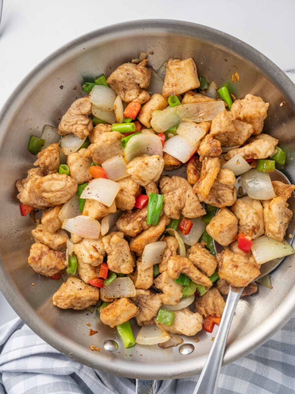 A spoon serves chinese chicken recipe from a wok.