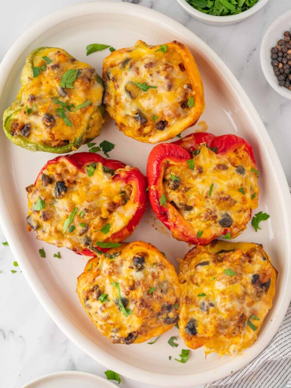 A plate with six stuffed peppers.