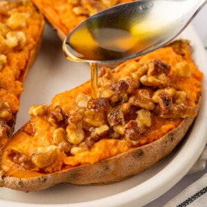 A drizzle of maple syrup is added to sweet potatoes.