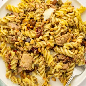 Pasta with tuna and pesto is on a plate with a fork.