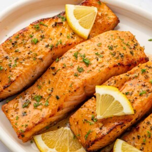 Air fried salmon filets on a platter with lemon slices.