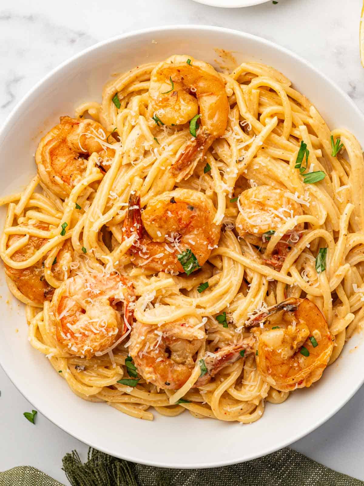 A serving of pasta and cajun shrimp on a plate.