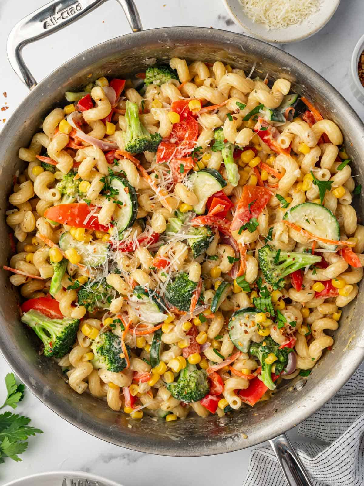 Parmasan cheese is sprinkled over veggies and pasta.