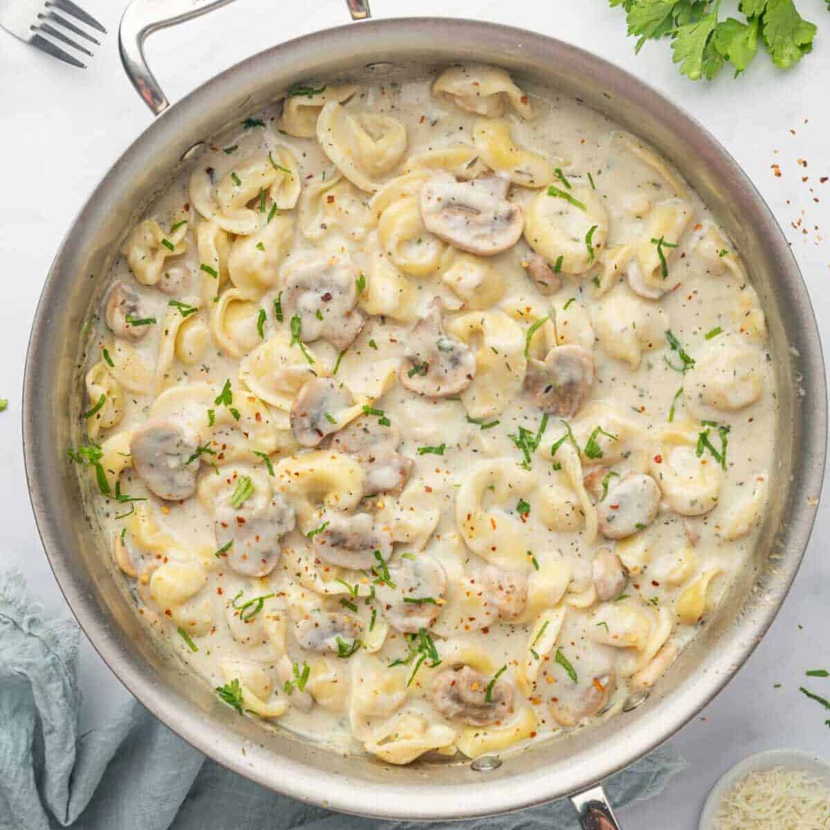 Cheese Tortellini Alfredo in a skillet.