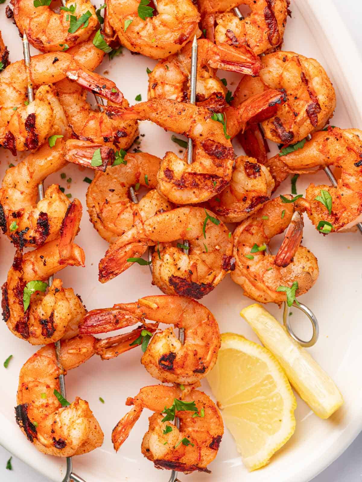 Grilled cajun shrimp skewers piled on a platter.