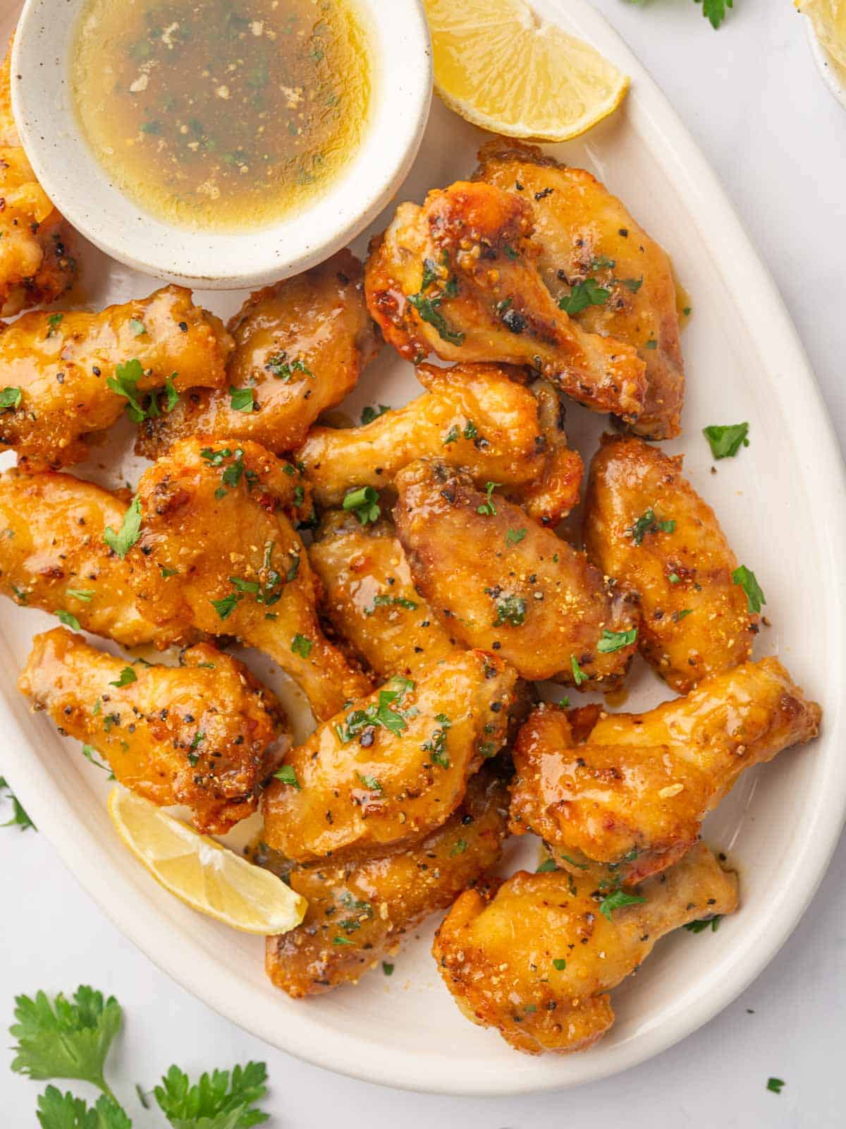 A plate of honey lemon pepper wings garnished with parsley.