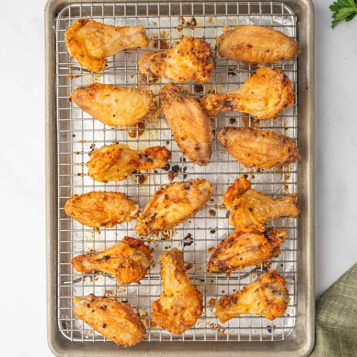 Baked honey lemon pepper chicken wings on a rack.