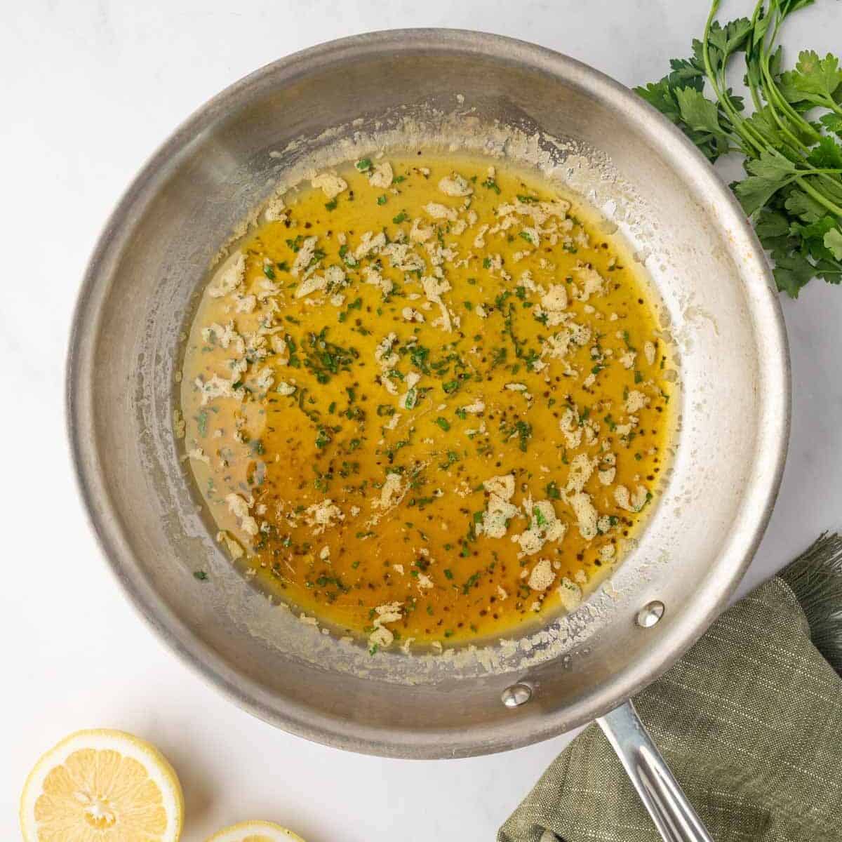 Honey lemon pepper sauce is prepared in a skillet.