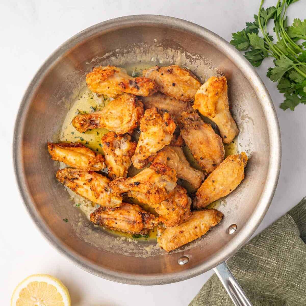 Baked chicken wings are tossed with honey lemon pepper sauce.