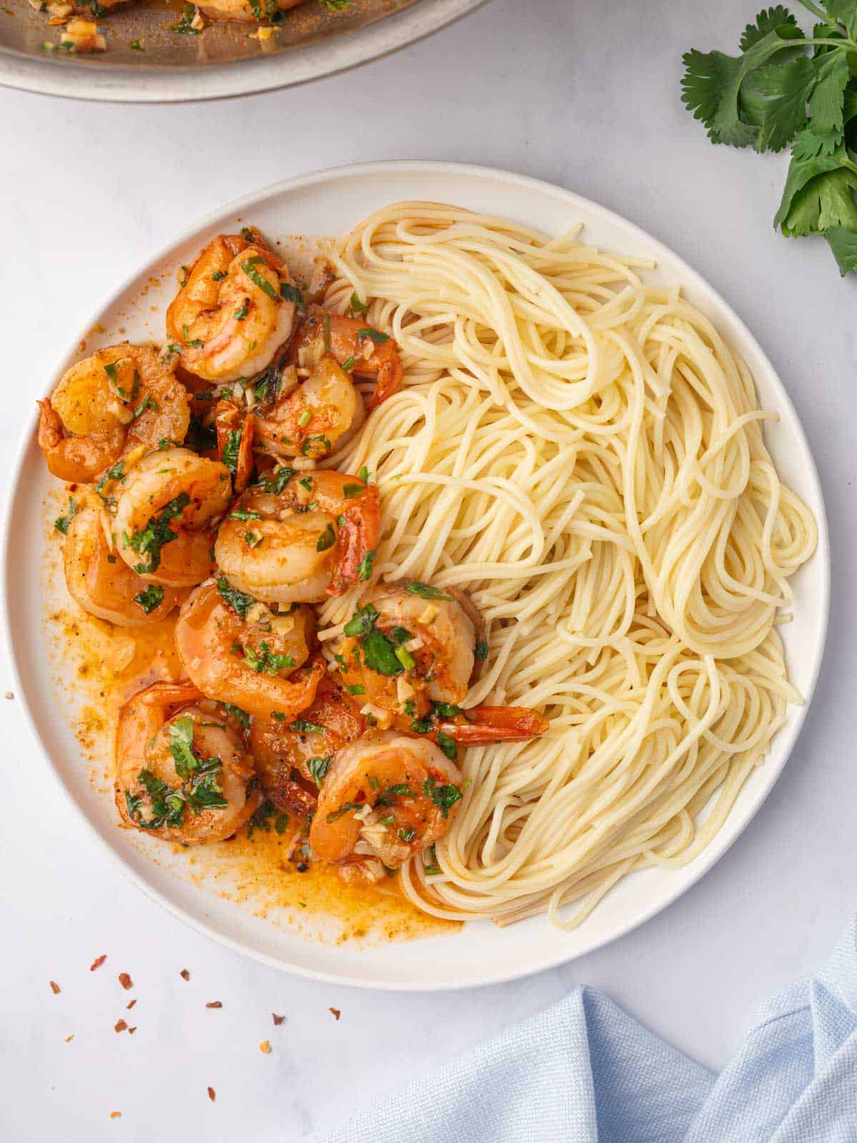 Spicy shrimp scampi pasta on a white plate.