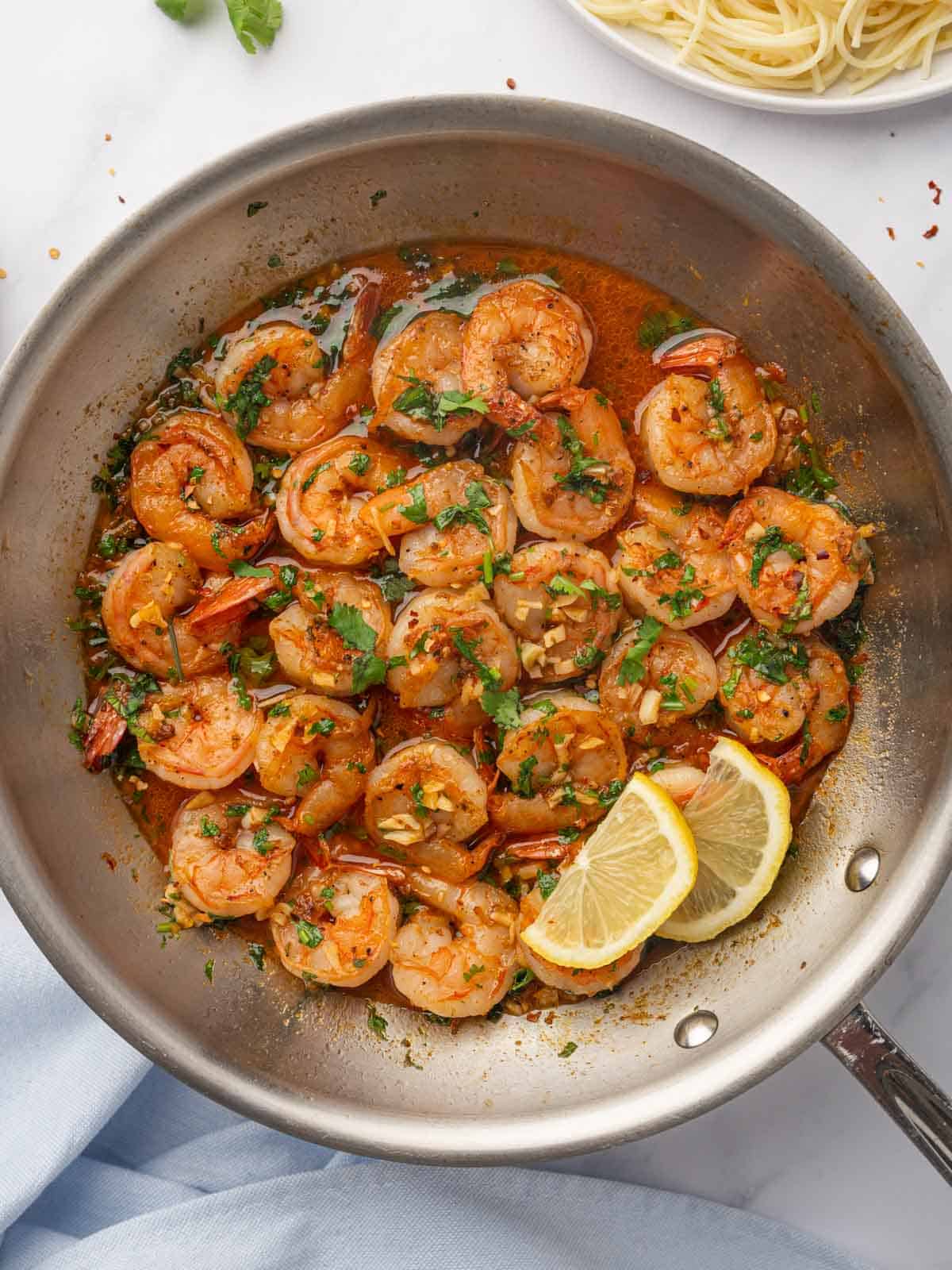 Shrimp sauteed in a spicy sauce in a skillet.