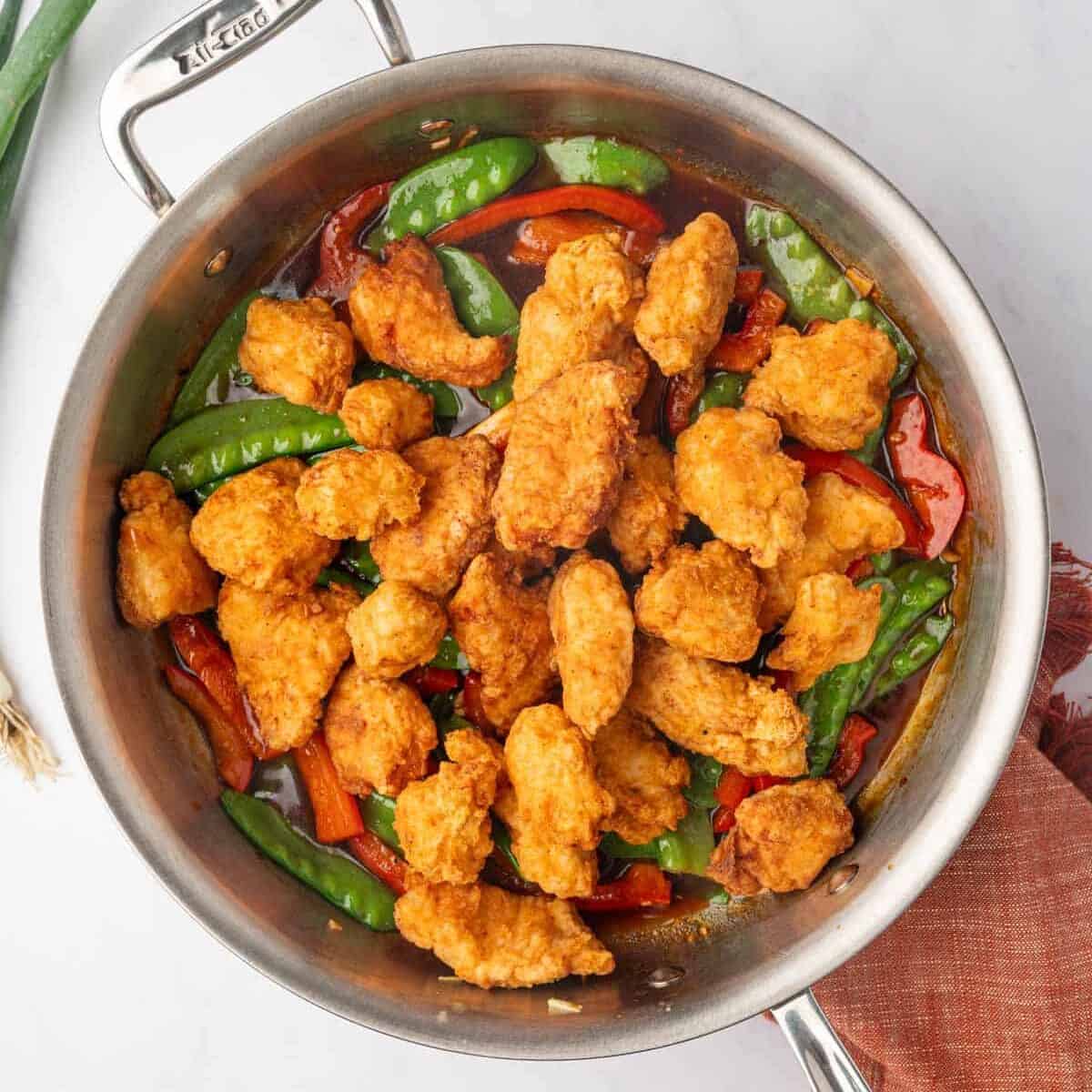 Fried chicken is added to the sauteed veggies.