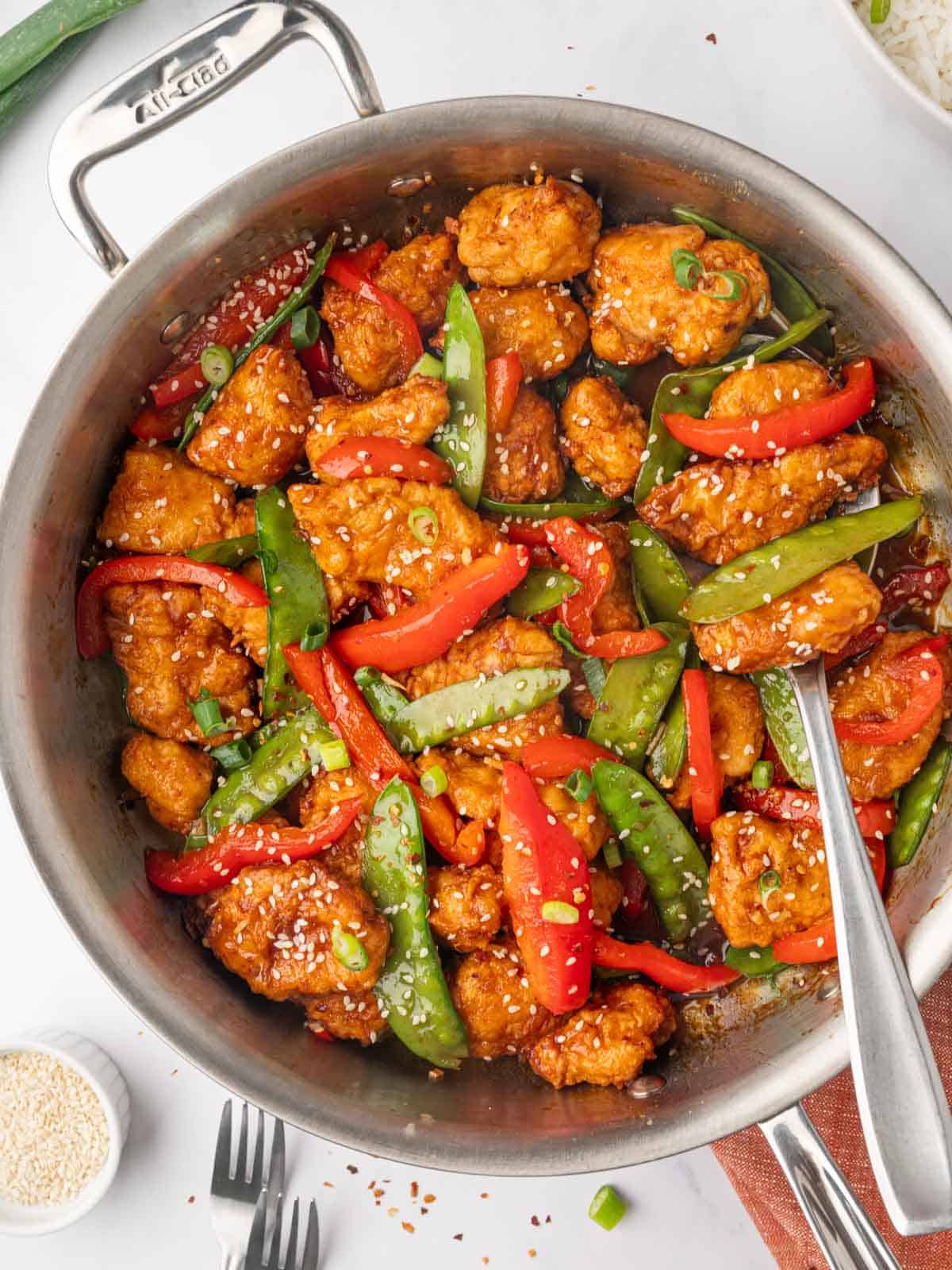 Chicken is combined with vegetable and sauce is a skillet.