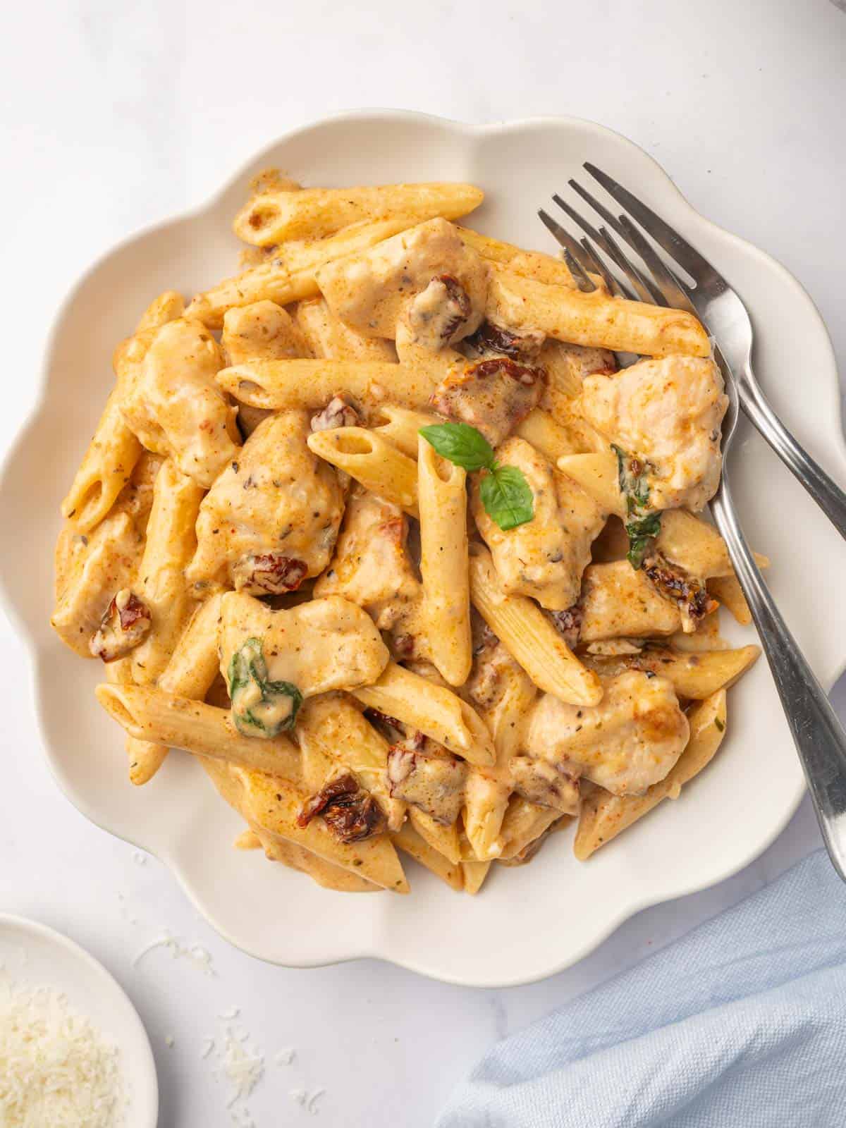 A plate of penne pasta with chicken.