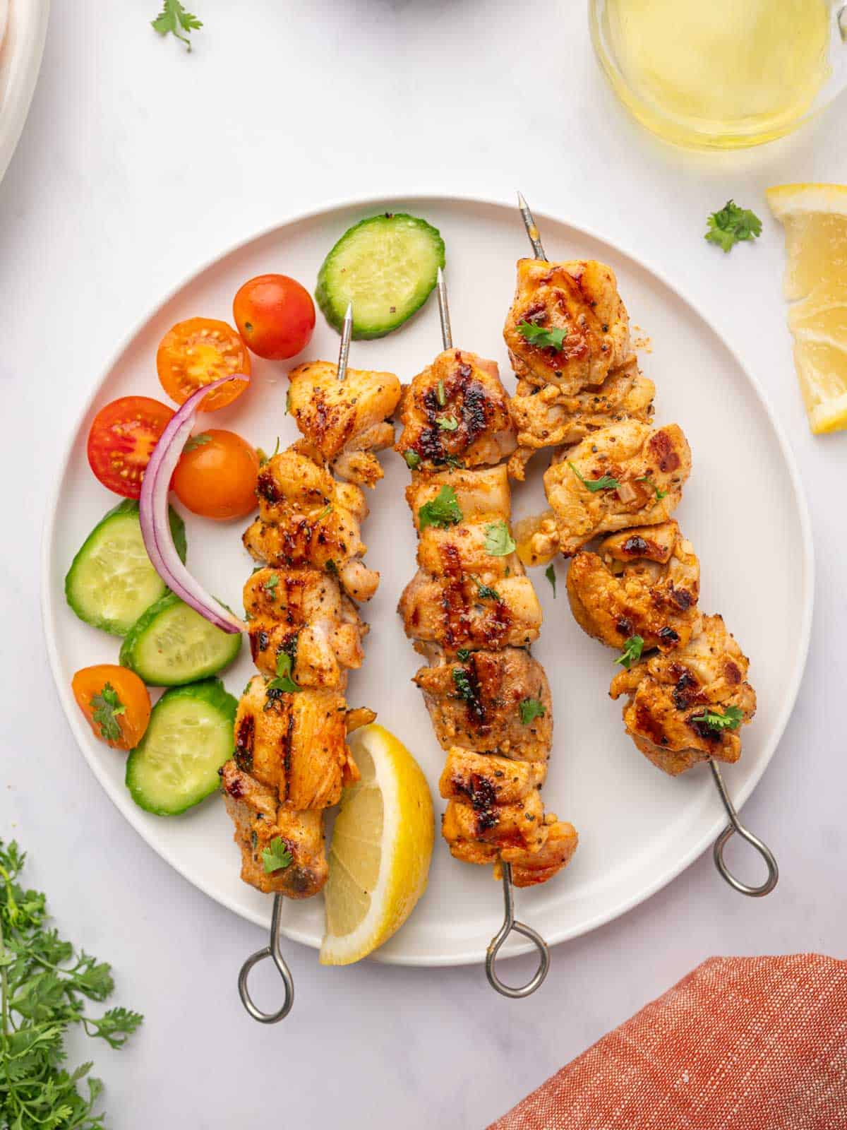 Grilled lemon pepper chicken skewers on a plate.