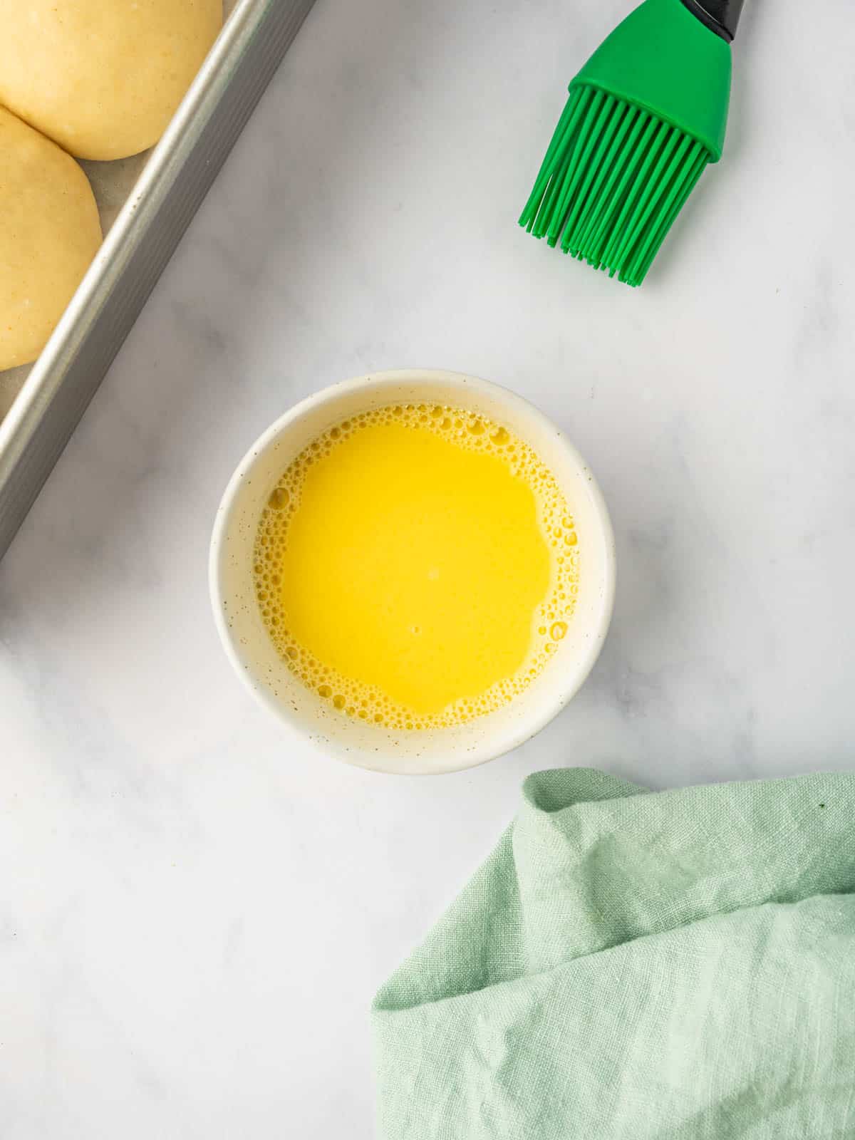 Egg wash for brushing the buns before baking.