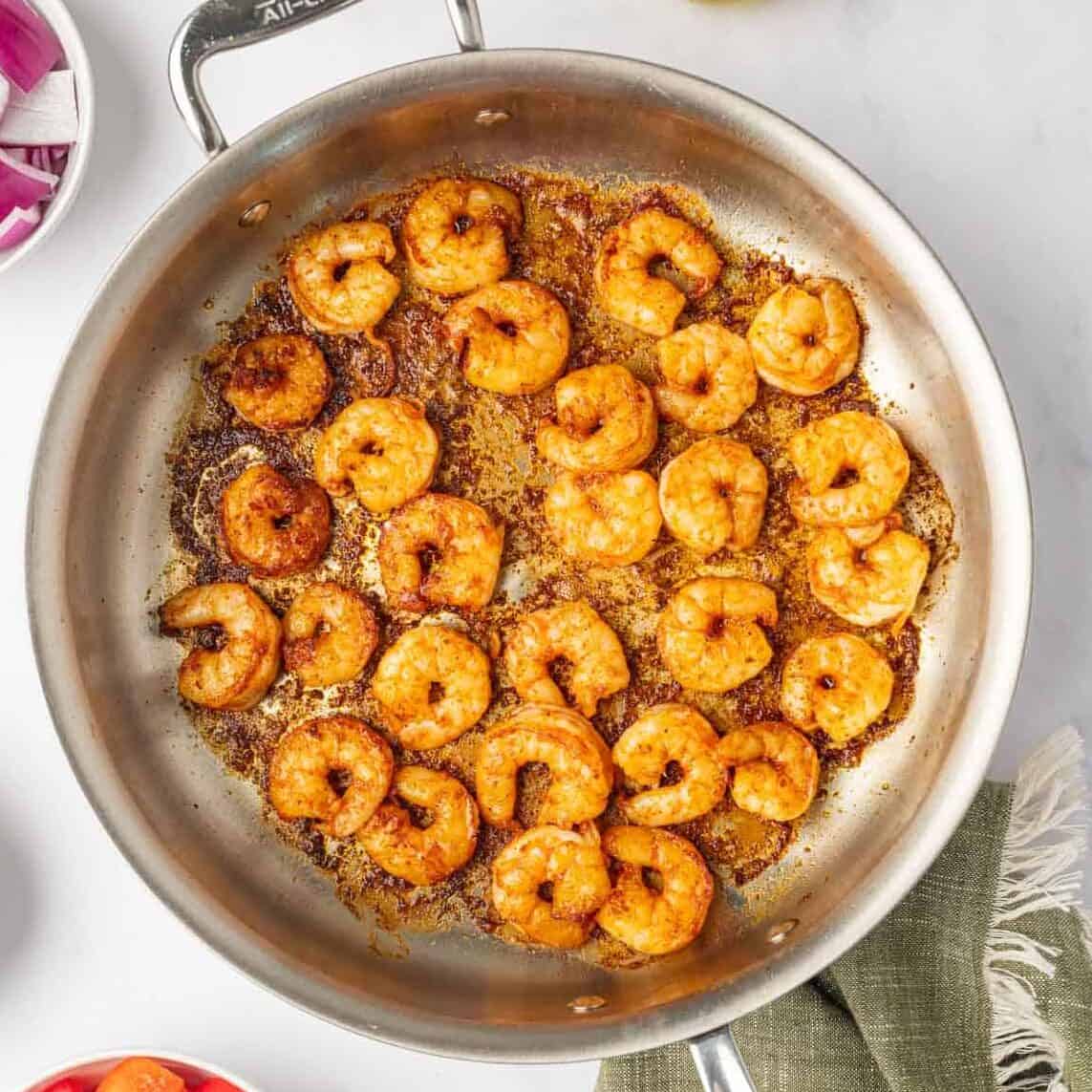 Sauteed shrimp in a skillet.