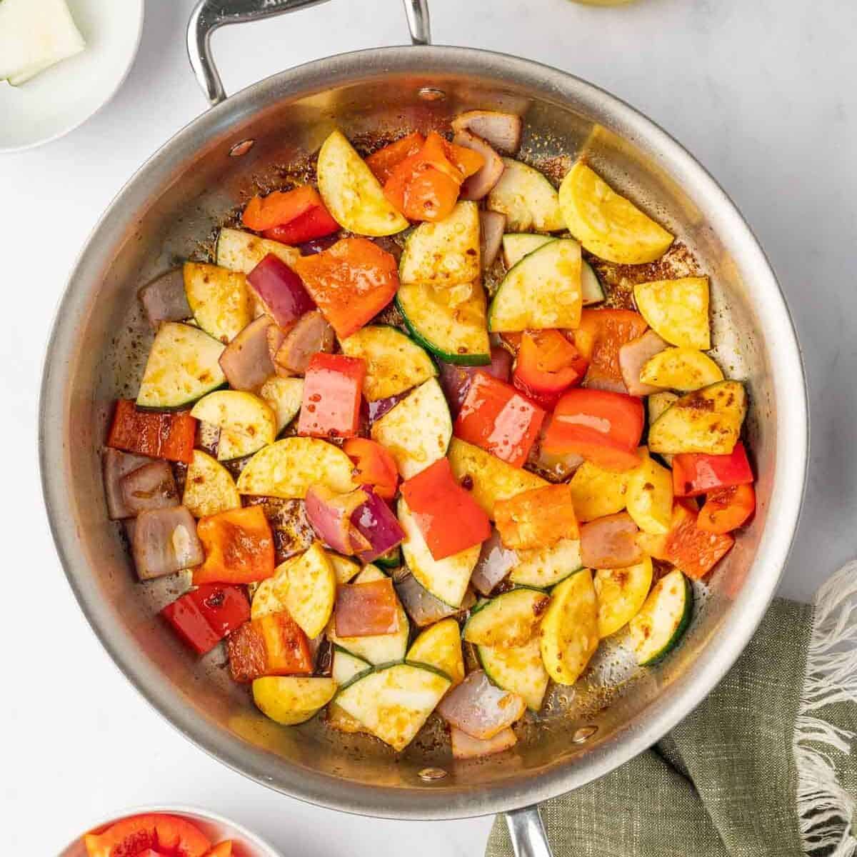 Sauteed veggies in a skillet.