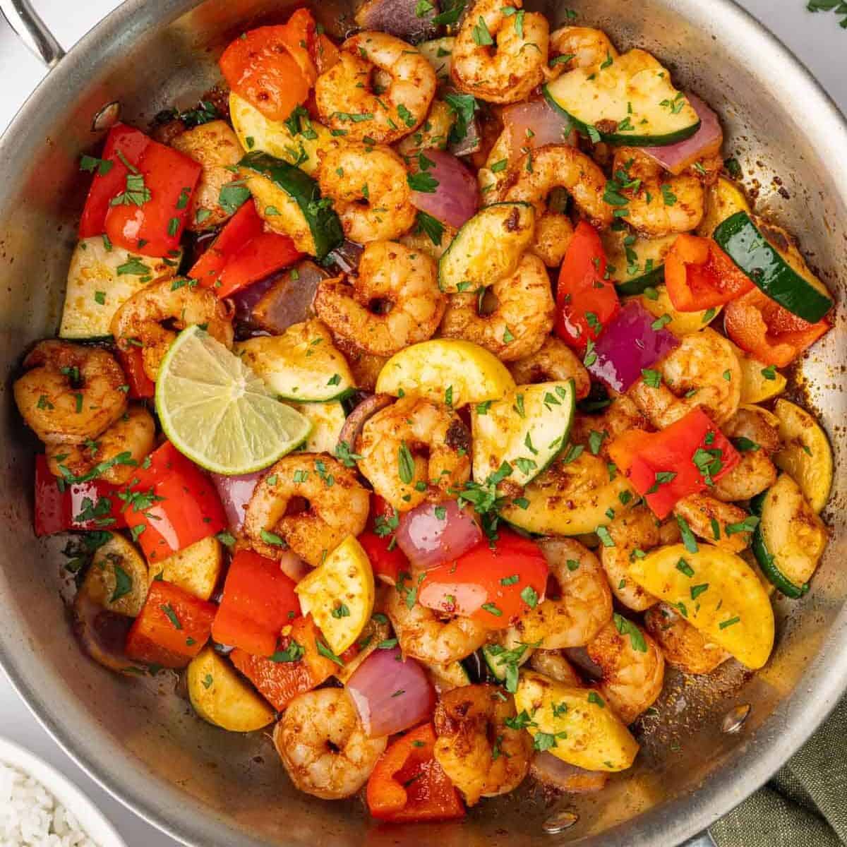 Shrimp and mixed vegetables cooked in a skillet.