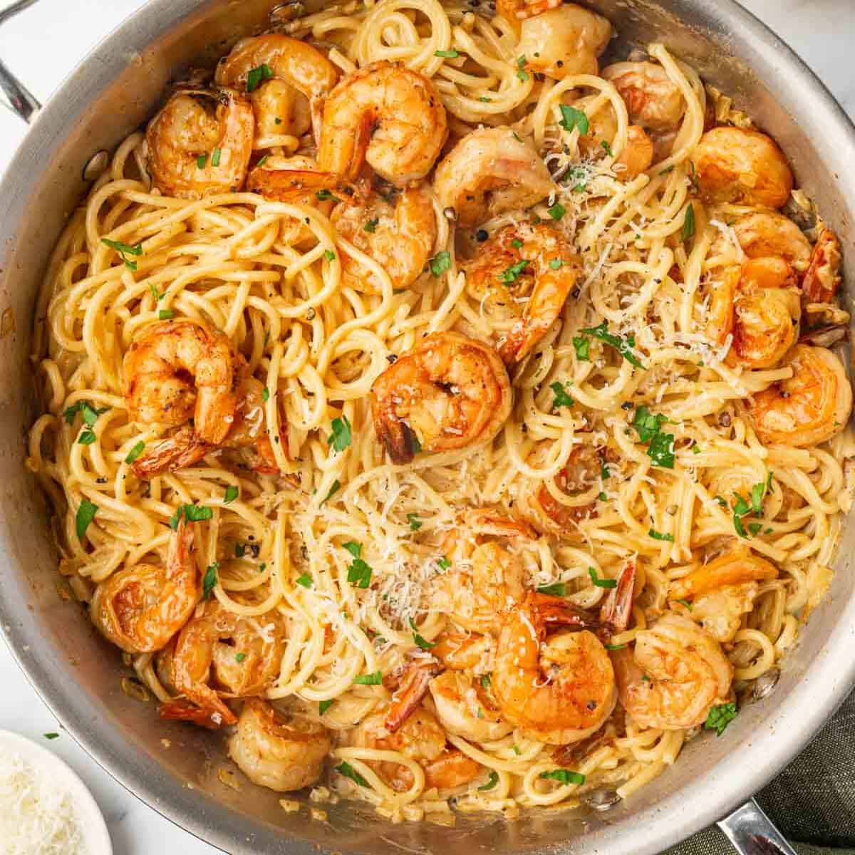 A skillet with spaghetti and spicy shrimp.